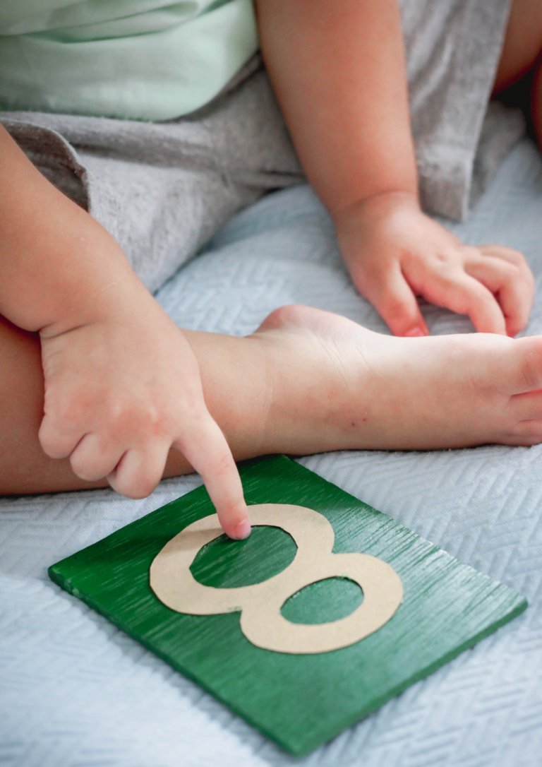 Kinderhandje dat wijst naar een bordje met een 8 erop.